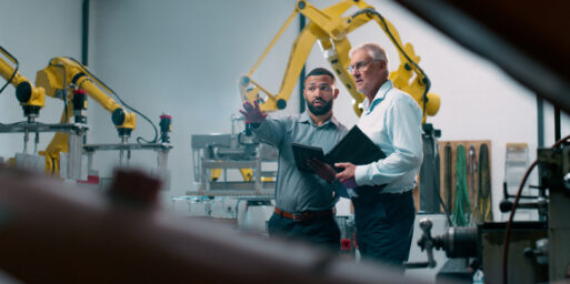Robotics, people and engineer tablet with industrial collaboration and planning in warehouse. Factory, engineering and futuristic work of manufacturing management with discussion for cnc automation