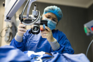Female doctor positioning microscope in operating theatre