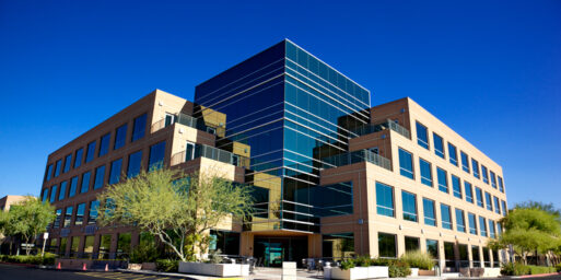 Scottsdale Business Park a Beautiful North Phoenix Office Building Stunning Scottsdale Arizona business building on blue backgrounded sky with matching blue glass windows beautifully landscaped with desert tolerant plant and trees on a clear day with set on a bright blue clear sky background.